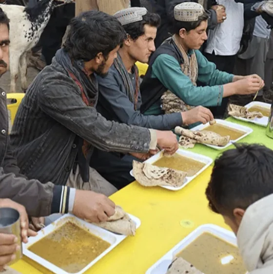 Men sharing hot meals at a Quba food distribution